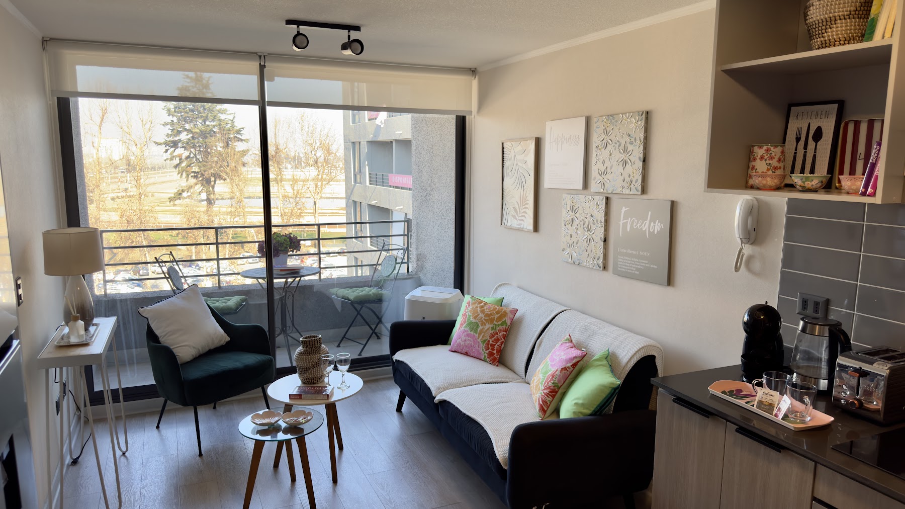 Living de Apart Stgo con ventanal y balcón